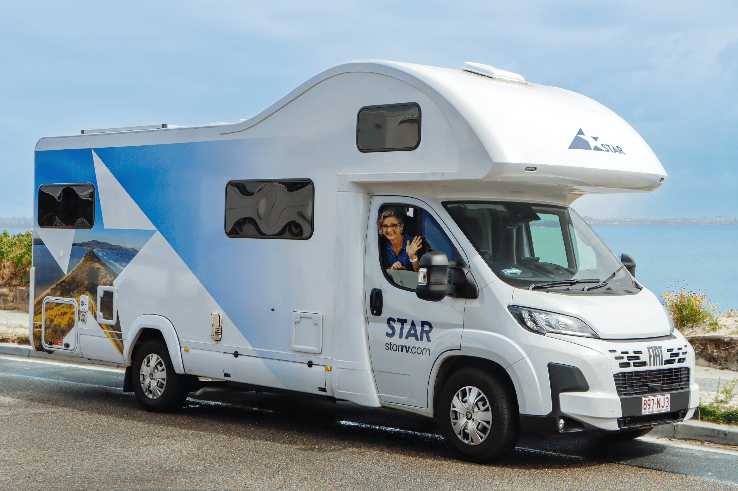 Julie Godwin waving out of a Star RV Polaris 6 motorhome